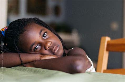 african american girl resting her head on her arms by stocksy contributor gabriel gabi