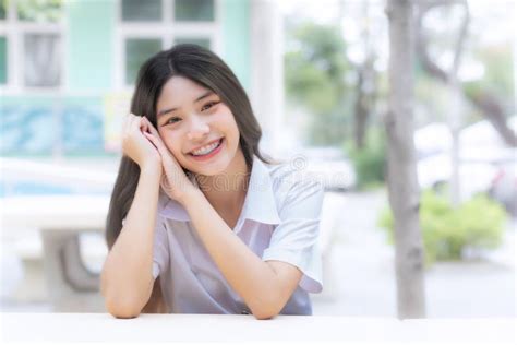Retrato De Una Linda Estudiante Tailandesa Con Uniforme Sentada Sonriendo Alegre Y