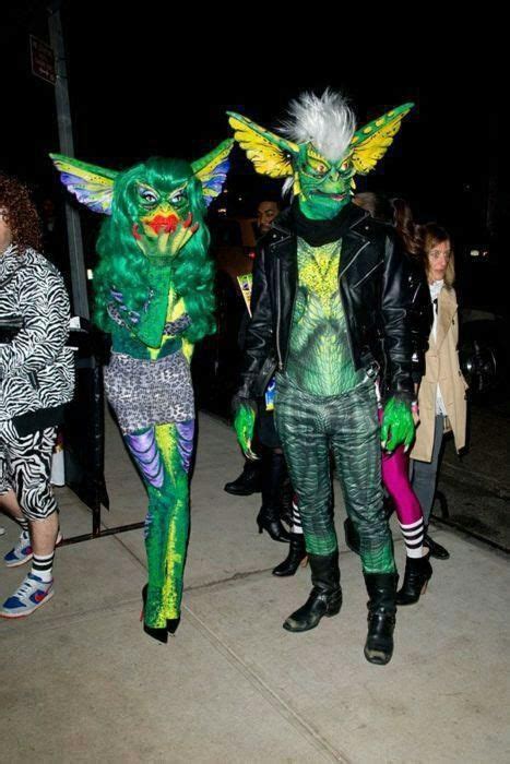 Two People Dressed In Costumes Walking Down The Street At Night With