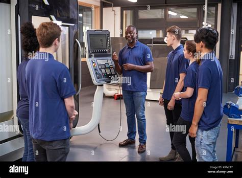 Engineer Showing Apprentices How To Use Cnc Tool Making Machine Stock