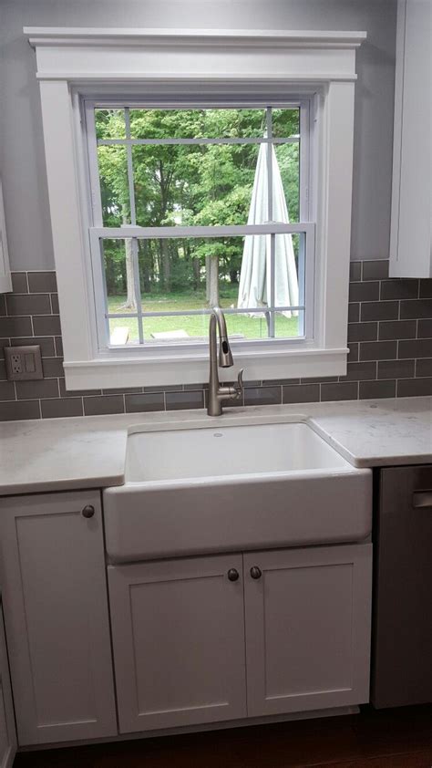 You could also taper your tile or angle your stone backsplash to gradually connect the top to the bottom. Cloud grey glass subway tile around window. Faucet is by ...