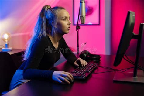 Focused Blonde E Sport Gamer Girl With Headset Playing Online Video