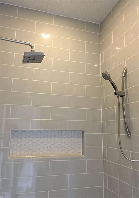 The Shower Head Is Mounted To The Side Of The Wall And It Has No Curtain
