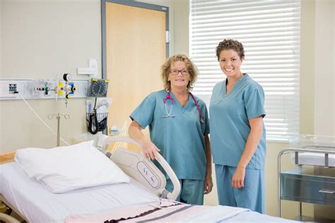 nurses standing together by bed in hospital room vänsterpartiet norrköping