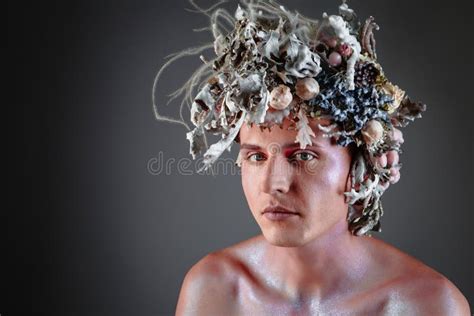 The Face Of A Male Model In A Headdress Of Flowers Filled With Wax