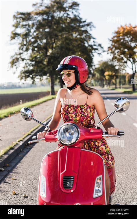 Happy Young Woman Riding Motor Scooter On Country Road Stock Photo Alamy