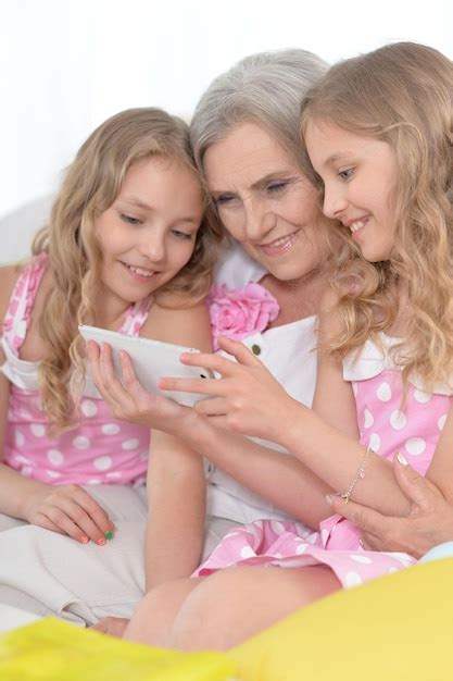 Premium Photo Granny With Granddaughters Using Smartphone