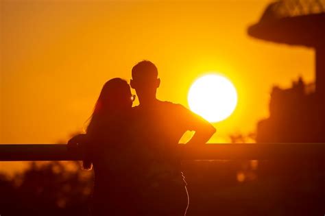 silhueta de duas pessoas apaixonadas no contexto do sol poente romance nos relacionamentos e na
