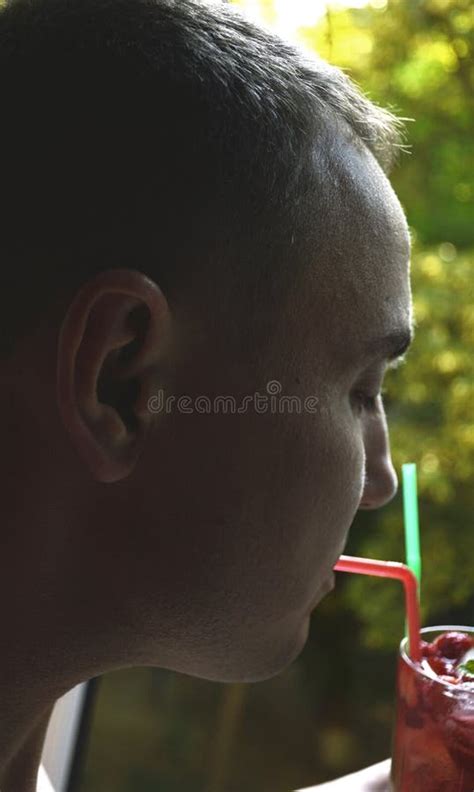 A Man Drinks A Soft Drink Or Cocktail From A Straw Thirst Quencher In The Heat Stock Photo