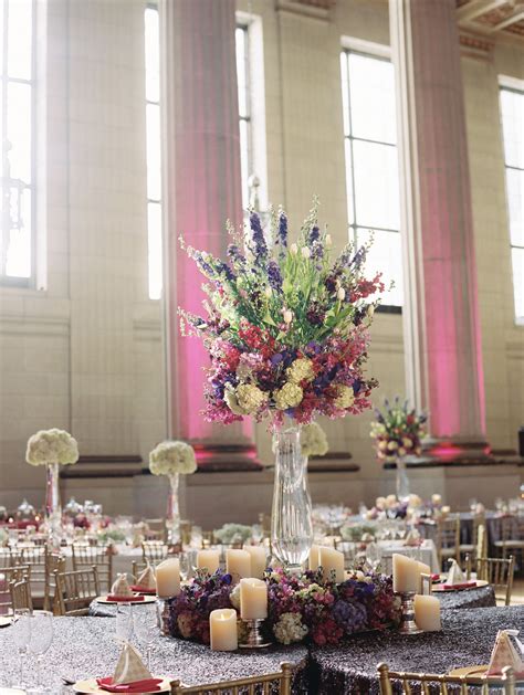 Tall Centerpieces Encircled with Flowers and Candles | Tall centerpieces, Centerpieces, Candles