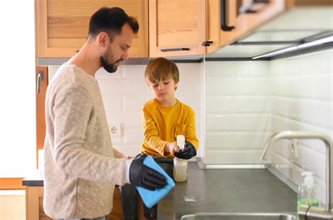 Padre E Hijo Limpiando La Cocina Foto Gratis