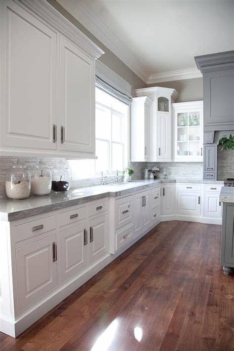 These blue grey kitchen cabinets and white farm sink deliver simplicity and warmth. Gray and White Kitchen Design - Transitional - Kitchen