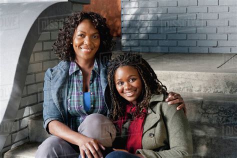 Black Mother And Daughter Sitting On Front Stoop Stock Photo Dissolve
