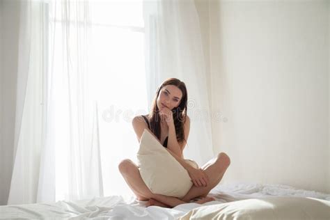 Brunette Woman After Sleeping In Bedroom Pillows On The Bed Stock Image