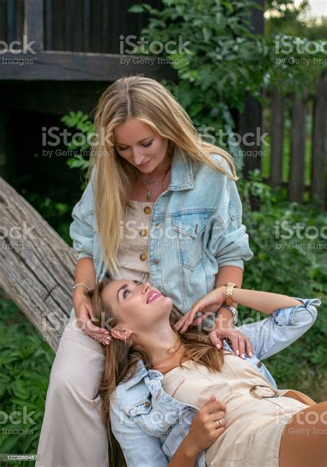 Vertical Photo Of Two Adult Sisters Who Are Looking At Each Other With