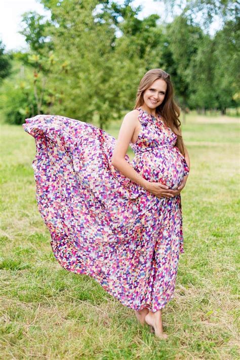 Beautiful Pregnant Woman Walking Barefoot In The Park In Long Colorful