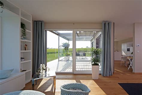 Ispirazione per una veranda design di medie dimensioni con parquet chiaro — houzz. Haus Brettheim - Fertighaus Keitel