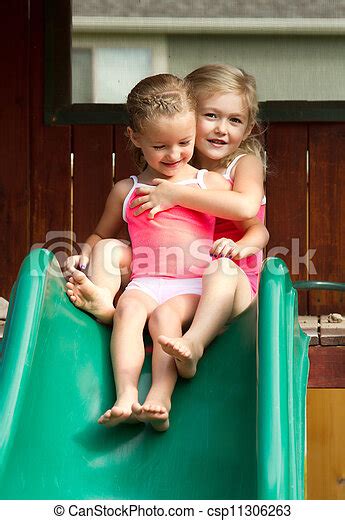 Two Girls Going Down Slide Two Girls Friends Or Sisters Going Down Slide Outdoors Canstock
