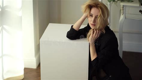 Blonde Girl In Black Jacket Sit Straightens Hair Stock Video Video