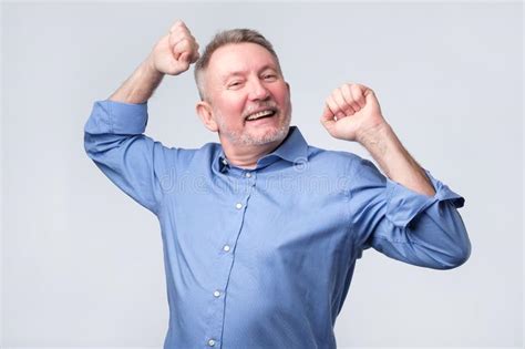 Happy Senior Strong Man Raising Clenched Fists In Hooray Gesture