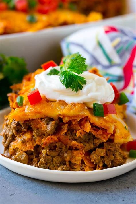 Printable recipe card with a full list of ingredients and to make this doritos casserole, i started by cooking some lean ground beef in a large frying pan. A piece of Dorito casserole with layers of tortilla chips ...