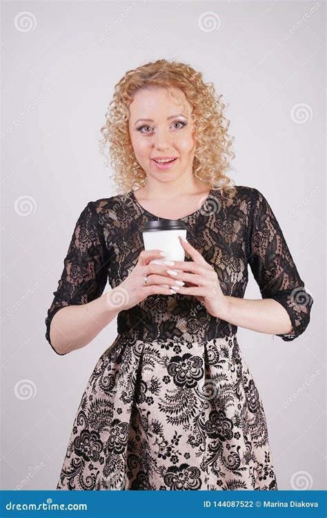 Cute Curly Blonde Girl Stands In Lace Short Evening Dress And Holds A