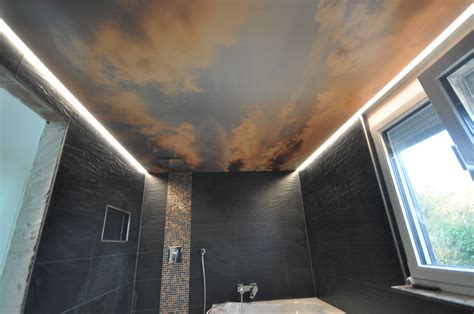 Modernes badezimmer en suite mit flächenbündigen schrankfronten, grauen schränken, badewanne in nische, duschnische, grauer wandfarbe, offener dusche, grauen fliesen, aufsatzwaschbecken. Spanndecke mit Wolkenhimmel bedruckt.LED Beleuchtung in ...