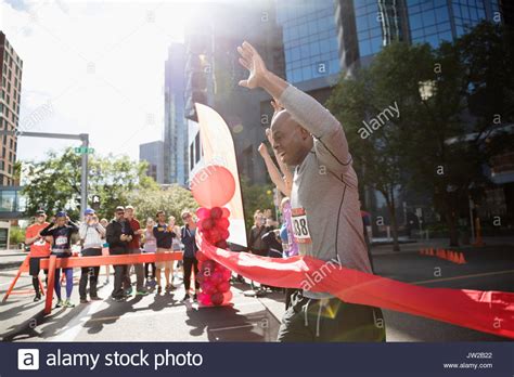 Exuberant Male Marathon Runner Crossing Finish Line With Arms Raised