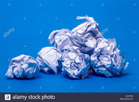 Pile Of Wrinkled White Pieces Of Paper Over A Blue Background Stock