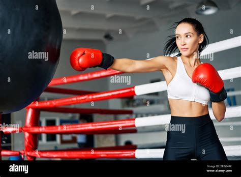 Female Boxer Hitting A Huge Punching Bag At Fitness Gym Woman