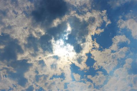 Stormy White Clouds On Blue Sky And Sun Behind Clouds Stock Photo