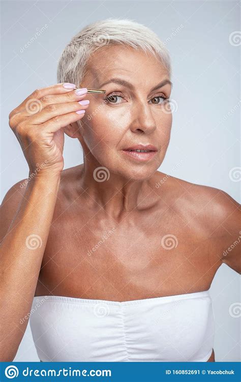 Attractive Mature Female Person Pinching Her Eyebrows Stock Image