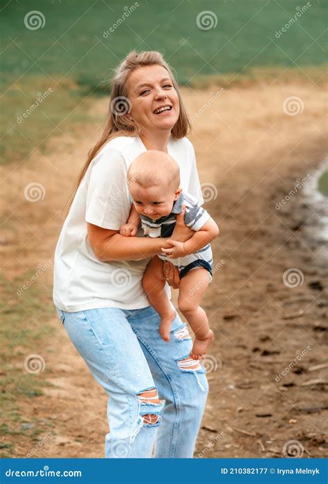 Madre Sosteniendo Y Abrazando A Hijo Afuera Imagen De Archivo Imagen