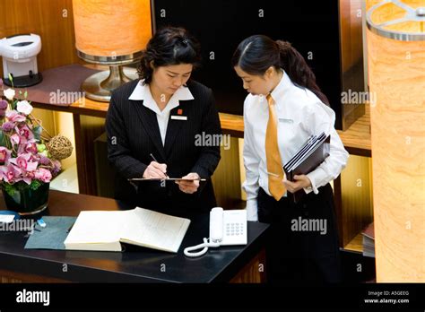 Hostess Looking At Reservation Book At Upscale Hong Kong Restaurant