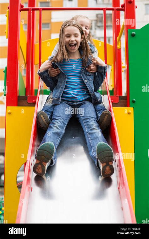Girls Slides Down The Hill On The Playground Stock Photo Alamy