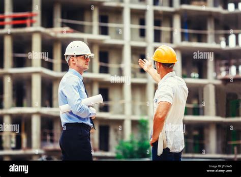 Architect And Builder Discussing At Construction Site Stock Photo Alamy