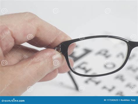 Male Hand Holding Black Eyeglasses For Vision Eyesight Examination Test Chart Stock Image