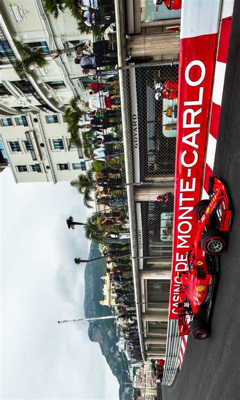 A Red Race Car Is Parked In Front Of A Tall Building