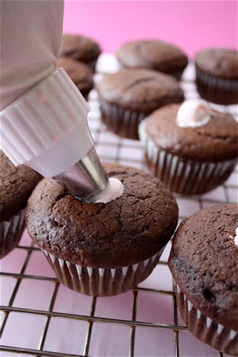 Squeeze about 2 teaspoons frosting into center of each cupcake for filling, being careful not to split cupcake. Cream Filled Chocolate Cupcakes with Chocolate Ganache ...