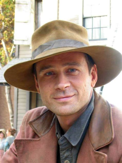 A Man Wearing A Brown Hat And Jacket