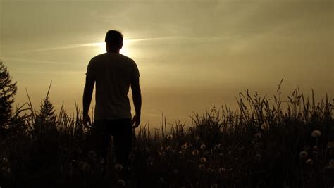 Sunset With Man Standing In Grassy Field Image Free Stock Photo