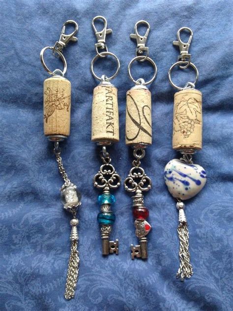 Four Wine Corks With Charms Attached To Them On A Blue Blanket One Has