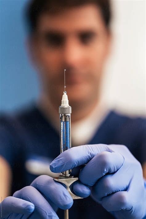 View Doctor With Syringe Is Preparing For Injection By Stocksy