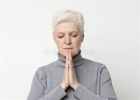 Beautiful Mature Woman Praying With Hands Clasped Near Face Stock Photo