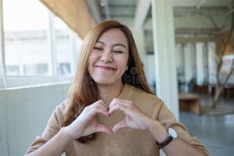 A Woman Making Heart Hand Sign With Feeling Happy Stock Photo Image
