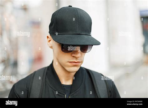 Handsome Guy In A Black Baseball Cap And Stylish Black Clothes
