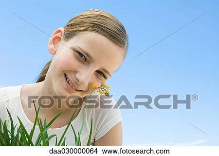 Preteen Girl Leaning Cheek Against Flower Picture Daa030000064