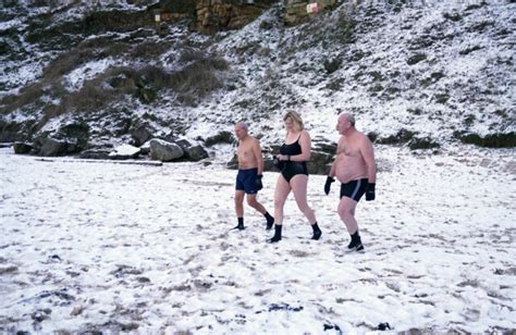 Keen Swimmers Brave Freezing Snow As They Take A Dip In Chilly Water