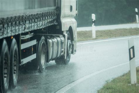 A Truck Is Driving On The Road In The Rain Stock Photo Image Of