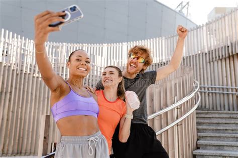 Group Of Excited Friends Taking Selfies During Outdoor Workout Stock